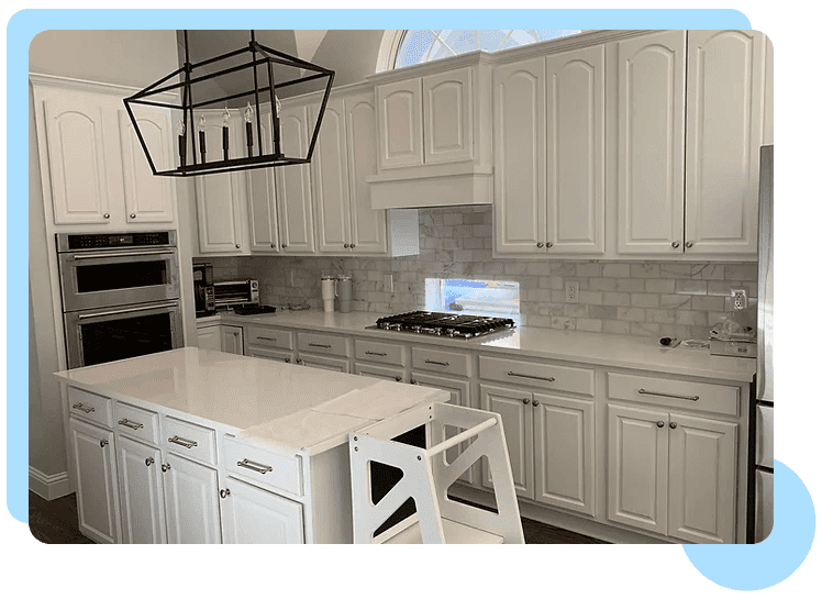 A kitchen with white cabinets and island in it